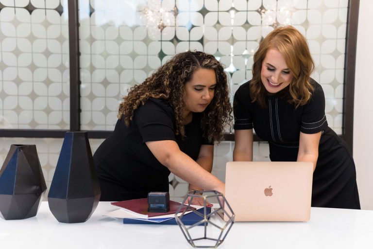 two people working in office looking at computer